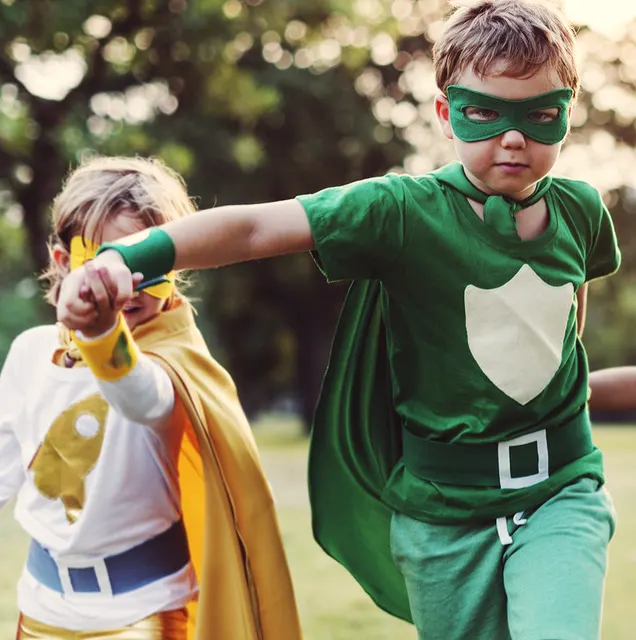 Bambini vestiti da piccoli eroi che giocano insieme